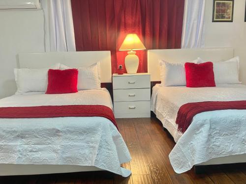 拉斯维加斯“Beautifull Cozy Studio…With Private Entrance”的卧室内的两张床和红色枕头