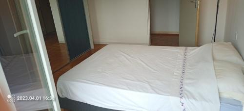 斯特拉斯堡chambre double chez l'habitant的一张白色的床,位于带镜子的房间里