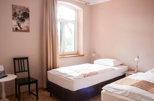 特伦Przystanek Tleń的配有2张床的带窗户和椅子的客房