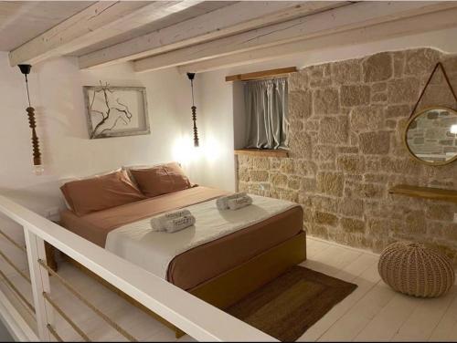 卡尔帕索斯Grannys Luxury Villas的卧室配有砖墙内的床铺