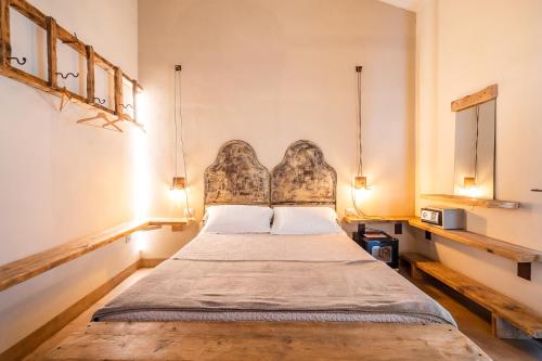 格罗塞托港Agriturismo Sweet Cottage的一间卧室配有一张带床头板的床和两盏灯。