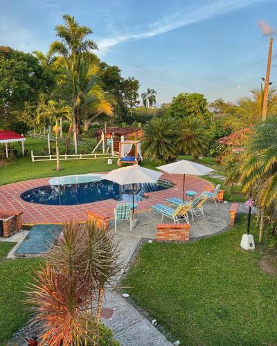 金巴亚Casa Lemar的一个带遮阳伞和椅子的游泳池以及一个游乐场