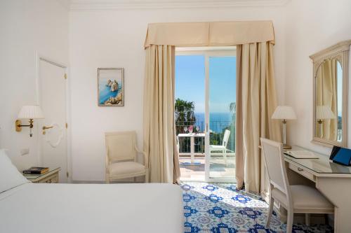 卡普里塞莱尼酒店的酒店客房设有一张床和一张书桌,享有美景。