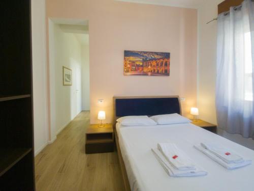 维罗纳Italianflat - Rentroom Verona的一间卧室配有一张带两盏灯的大型白色床。