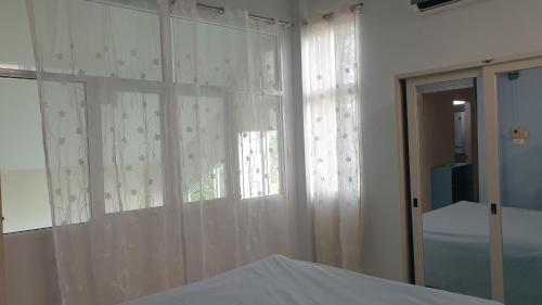 春蓬บ้านOrman的卧室配有白色窗帘和窗户