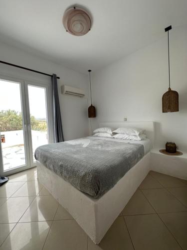 圣安娜纳克索斯Naxian Touch的白色的卧室设有床和大窗户