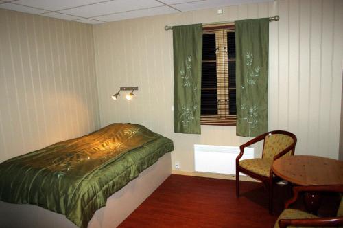 卡拉绍克杰古尔艾斯图山林小屋的卧室配有1张床、1张桌子和1把椅子