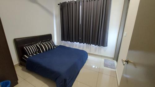加影TL145 The Strata的一间卧室配有一张带蓝色毯子的床和窗户。
