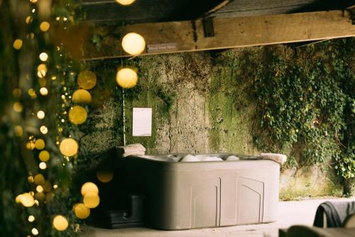 斯特拉德巴利Fitz Of Inch - Self Catering House and Barns的浴缸位于墙上,配有灯