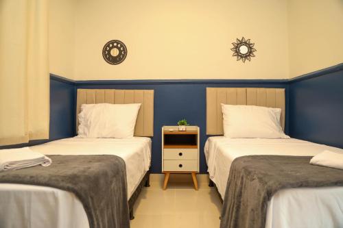 帕尔马斯AP 104-A Térreo Completo Aconchegante的一间卧室设有两张床,墙上挂着一个时钟。
