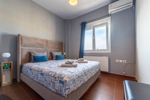 海若克利欧MegaLuxe Apartment的一间卧室配有一张带蓝色枕头的床和一扇窗户。