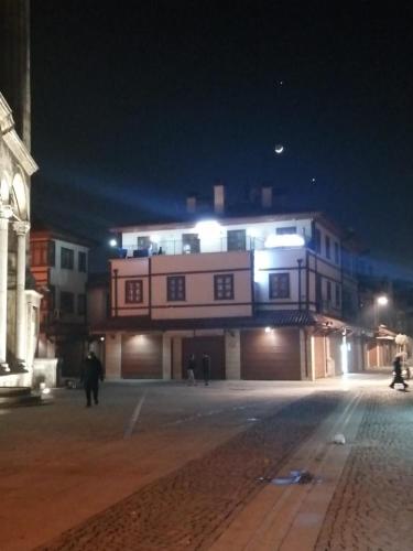 科尼亚ESER PALAS OTELİ的一座晚上有人在楼前行走的建筑