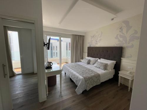 利多迪耶索罗切利尼公园酒店的卧室配有床、桌子和窗户。