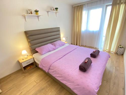 Mataruška BanjaApartman MiNa的一间卧室配有一张带粉红色床单的大床