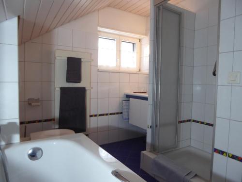 克罗伊茨林根22 – Zimmer & Zmorge的带浴缸、卫生间和盥洗盆的浴室