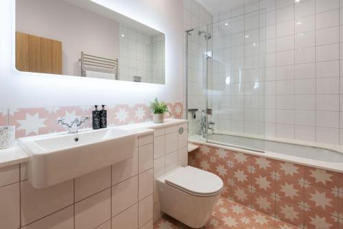 索尔科姆Goodshelter Bay的浴室配有盥洗盆、卫生间和浴缸。
