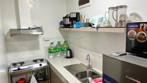马尼拉Jannah’pad的厨房配有水槽、炉灶和苏打水瓶。