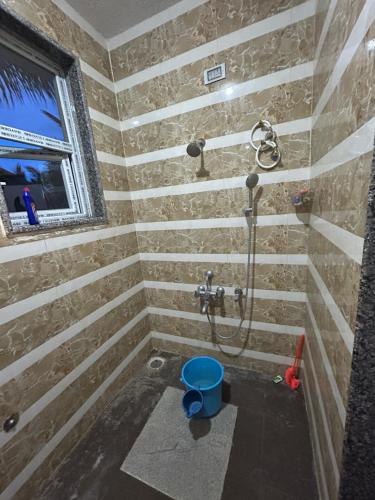 ChannarāyapatnaKashi Farm House的带淋浴和蓝色桶的浴室