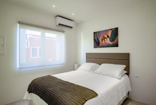 Santa CruzTrankilidad Apartments的卧室配有一张大白色床和窗户