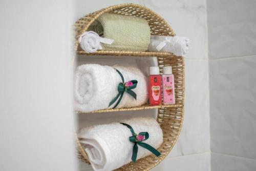 阿彻奇洛斯Fileo Family and Friends Living的一个带毛巾和其他浴室用品的柳条篮
