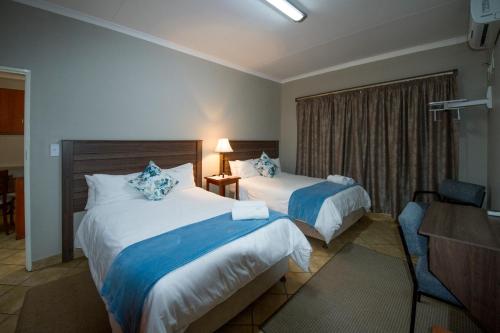 莫科帕内马如拉山林小屋的酒店客房配有两张床和一张书桌