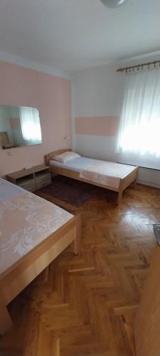 VrlikaKuća za odmor Varoš的一间卧室设有两张床,铺有木地板