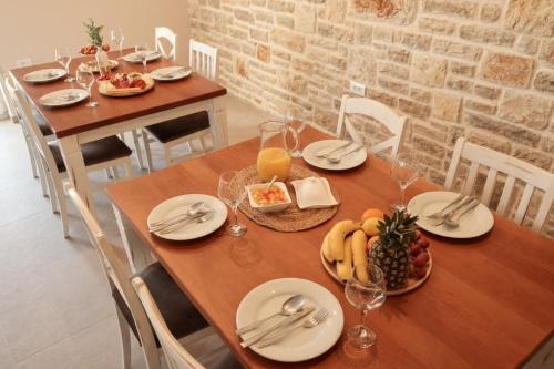 普利拉卡Castello Exclusive rooms with breakfast的一张木桌,上面放着食物和水果盘