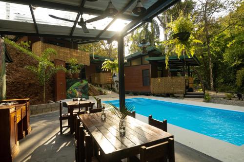 曼努埃尔安东尼奥Riverside Villas的一个带桌子和游泳池的庭院
