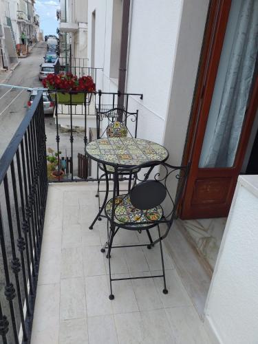 佩斯基奇Affittacamere Casa Flora的阳台配有桌椅