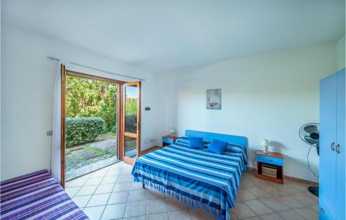 圣特奥多罗2 Bedroom Cozy Apartment In San Teodoro Ot的一间卧室设有蓝色的床和滑动玻璃门