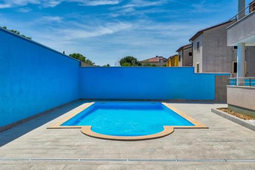 班约勒Boho Bliss Apartment Istria的一个带蓝色墙壁的庭院内的游泳池