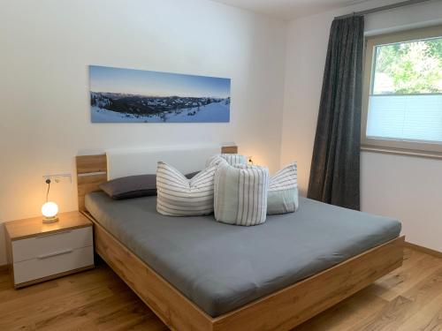 奥法赫Appartement Dorfblick的卧室配有带枕头的床铺和窗户。