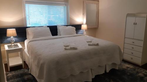 皮克顿Eliken House Suites的一间卧室设有一张大床和一个窗户。