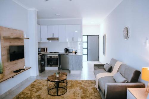 BroadhurstLuxury Self Catering Studio - HoneyBee Apartment的客厅配有沙发和桌子
