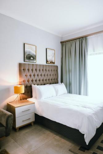 BroadhurstLuxury Self Catering Studio - HoneyBee Apartment的一间卧室设有一张大床和一个窗户。