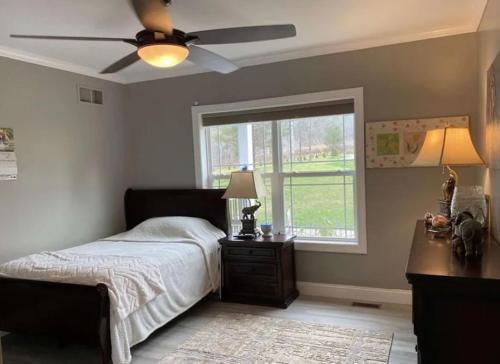 EndwellCountry home的一间卧室配有一张带吊扇和窗户的床。