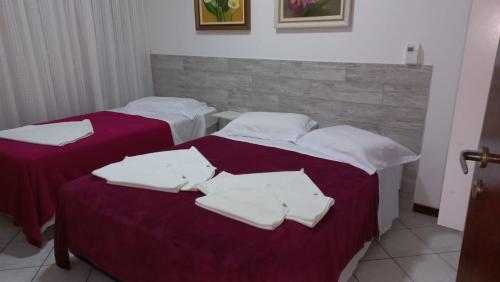 邦比尼亚斯Apto. 2 quartos em Bombinhas (60 m da praia)的客房内的两张床和白色毛巾