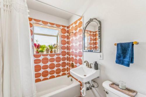 二十九棕榈村The Maude House的橙色和白色的浴室设有水槽和卫生间