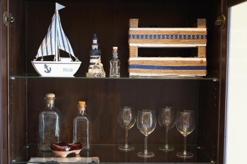 卢安科ALMAR, Apartamento en Luanco.的酒架上装有酒杯的货架和船上的船