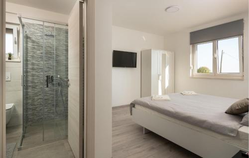 瓦图拉Nice Home In Valtura With Kitchen的一间卧室设有一张床和一个玻璃淋浴间