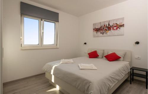 瓦图拉Nice Home In Valtura With Kitchen的白色卧室配有一张带红色枕头的大床