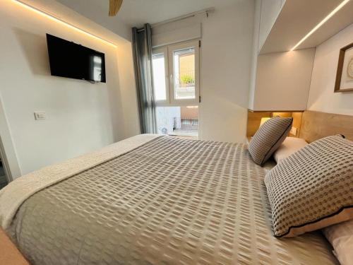 贝尼萨El Piset 124的卧室配有一张大床,墙上配有电视