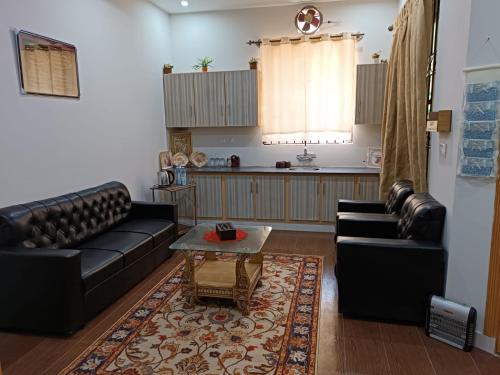 伊斯兰堡Islamabad Comfort Home的客厅配有两张真皮沙发和一张桌子