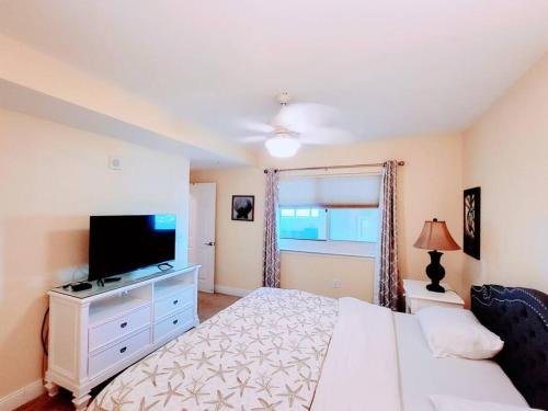 巴拿马城海滩Your Ultimate Beachfront retreat! Brand New Flooring!!的卧室配有白色的床和平面电视。