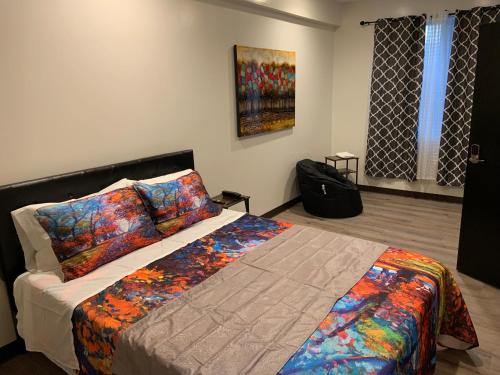 圣地亚哥Hotel Gigi的卧室配有一张床,墙上挂有绘画作品