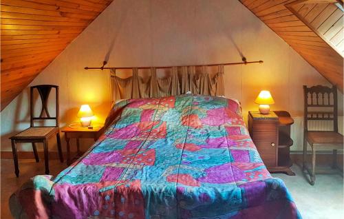 Le Cloître-Saint-Thégonnec茹德卡尔维丽度假屋的一间卧室配有一张带五颜六色棉被的床