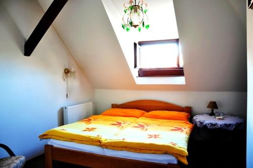 捷克克鲁姆洛夫柏德来迪酒店的一间卧室配有带橙色枕头的床和窗户。