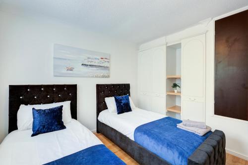 彼得伯勒Great Location Free Parking Contractor Leisure的一间卧室配有两张带蓝色枕头的床