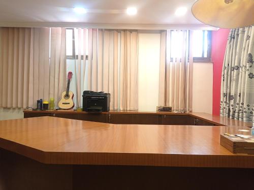 加德满都Janaki House的一间房间,里面配有一张桌子和吉他