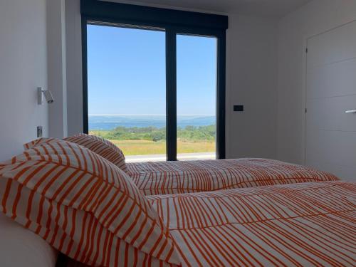 格罗韦Casa Leiras的一间卧室设有一张床和一个大窗户